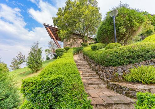 a stone path in a garden with a street light at Gorilla Heights Lodge by NEWMARK in Kisoro