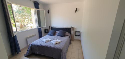 une chambre avec un lit avec deux serviettes dessus dans l'établissement Mini villa - T2 climatisé, proche des plages, à Eccica-Suarella