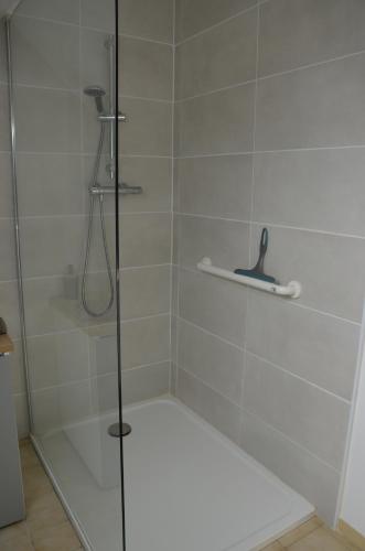 une douche avec une porte vitrée dans une salle de bain dans l'établissement Maison proche de la mer, à Saint-Méloir-des-Ondes