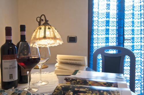 a table with a glass of wine and a lamp at Altavilla Locanda E Tipica Trattoria in Bianzone