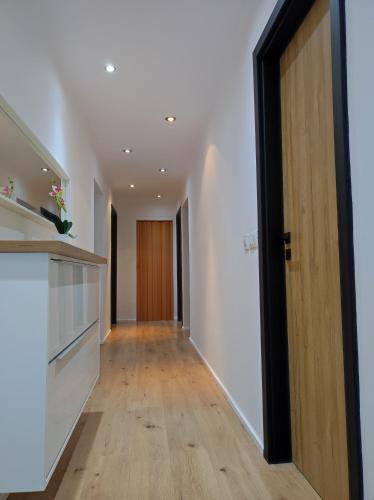 a hallway with white walls and a wooden door at B&D apartment in Maribor