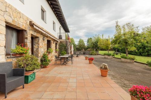 an outdoor patio with tables and chairs and plants at Zelaikoa Behekoa - baskeyrentals in Zestoa