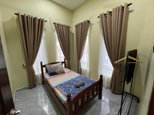 a bedroom with a bed in a room with curtains at Robi Homestay in Alor Setar