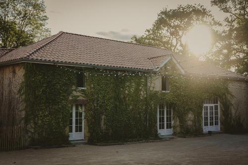 a ivy covered house with white windows and white doors at Domaine de Bassibé in Ségos