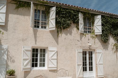 a white building with white windows and ivy at Domaine de Bassibé in Ségos