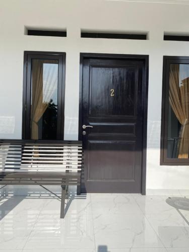 a bench in front of a building with two doors at Kamar no 1 in Sampal 2