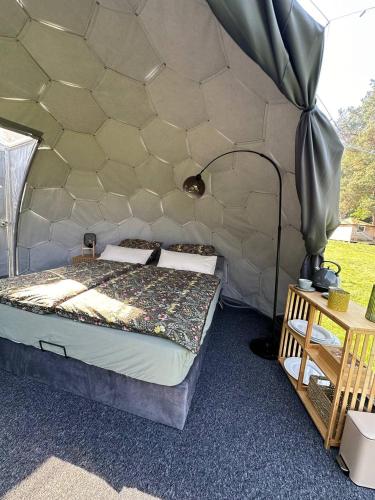 a bedroom with a bed in a tent at Paradiesufer am See in Milmersdorf