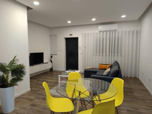 a living room with yellow chairs and a couch at Refúgio Vale da Pipa in Figueiró dos Vinhos