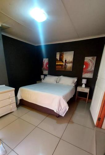 Un dormitorio con una cama grande con una pared azul. en Nelspruit holiday house, en Mataffin