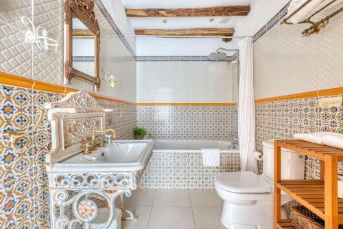 a bathroom with a tub and a toilet and a sink at Le Gîte du Château de la Vérie in Challans