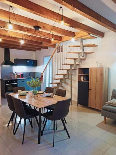 une table à manger avec des chaises et un escalier dans l'établissement Gite de l'Auzon Vallon Pont d'Arc 3ch, à Vallon-Pont-dʼArc