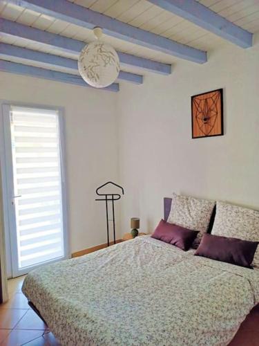 une chambre avec un grand lit et une fenêtre dans l'établissement Gite de l'Auzon Vallon Pont d'Arc 3ch, à Vallon-Pont-dʼArc