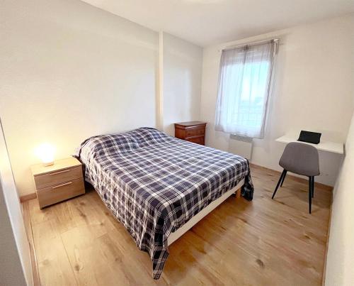 a bedroom with a bed and a desk and a window at Les boucaniers in Berck-sur-Mer