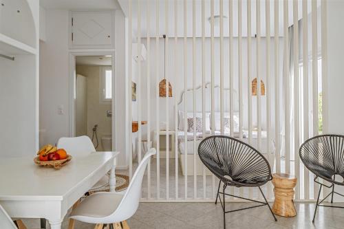 a white dining room with a table and chairs at Aeolos Thalia Suite in Agkidia