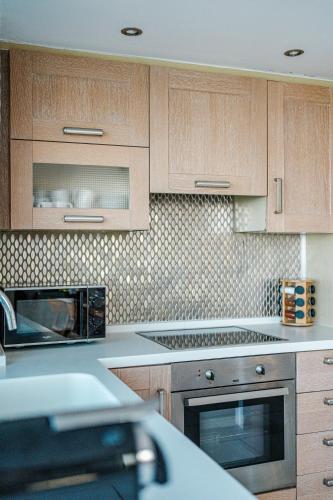 a kitchen with wooden cabinets and a microwave at Yellow Dream Villas in Chorafakia