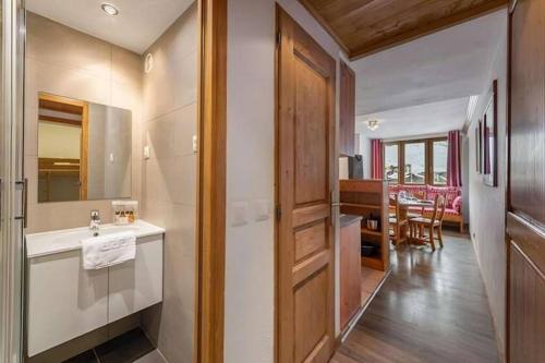 ein Bad mit einem Waschbecken und ein Esszimmer in der Unterkunft Arcelle Condo by Alpstays in Val Thorens