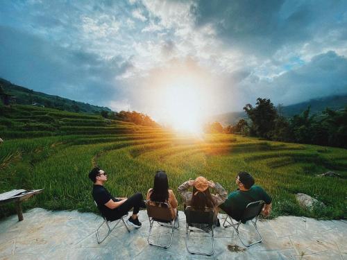 a group of people sitting in chairs in a field at Boutique En Hotel Sapa in Sa Pa