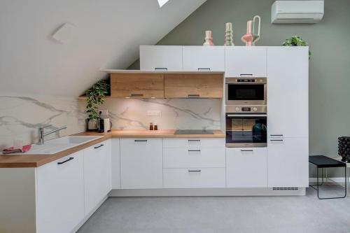 a white kitchen with white cabinets and appliances at Josette - Château d'Amboise in Amboise