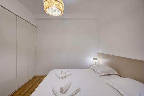 a white bedroom with a bed with white sheets at Josette - Château d'Amboise in Amboise