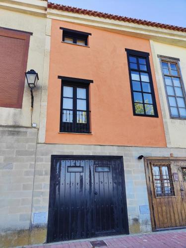 a building with two black doors and windows at Casa Cincilia in Chinchilla de Monte Aragón