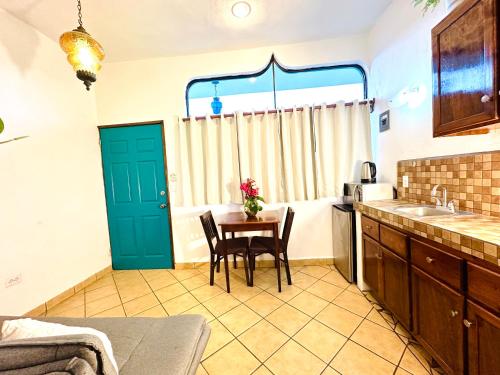 a kitchen with a table and chairs and a sink at CABO BOHEMIA Tropical Garden Studios in Cabo San Lucas