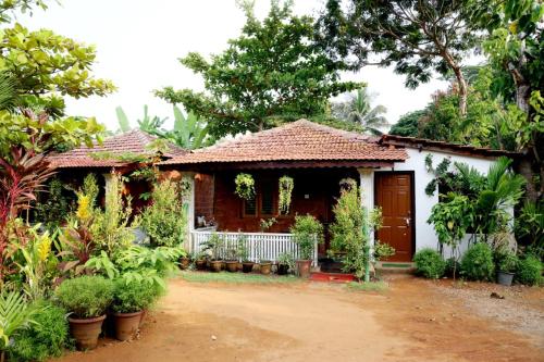 a small house in a garden with plants at Niyati Home Stay in Gokarna
