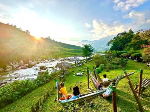 a group of people sitting in hammocks overlooking a river at Boutique En Hotel Sapa in Sa Pa