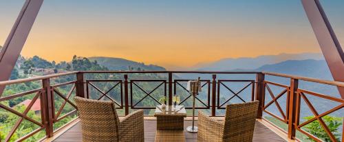 a balcony with chairs and a view of mountains at Gorilla Heights Lodge by NEWMARK in Kisoro