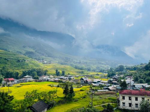 a small village in a green valley with mountains in the background at Boutique En Hotel Sapa in Sa Pa
