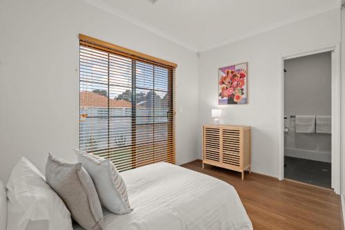 a bedroom with a bed and a large window at Caladenia Villa Urban Retreat in Perth