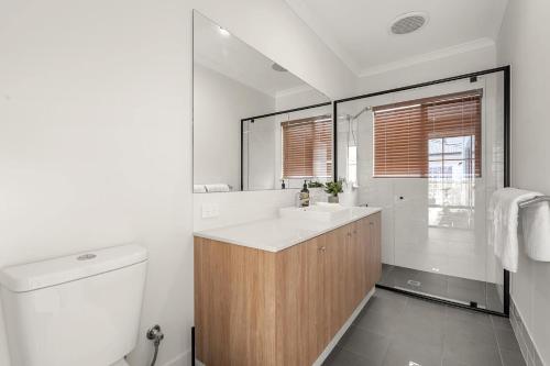 a white bathroom with a sink and a toilet at Caladenia Villa Urban Retreat in Perth