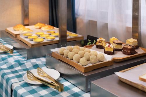 a buffet with several different types of cakes and pastries at 凯旋龙酒店广州区庄地铁站店 in Guangzhou