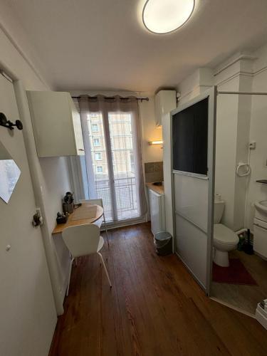 une petite cuisine avec un bureau et une télévision dans la chambre dans l'établissement Studio 300m de la plage, au Havre