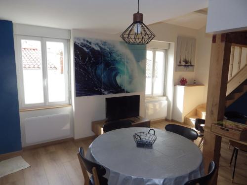 un salon avec une table et une télévision dans l'établissement la vague, à Les Sables-dʼOlonne