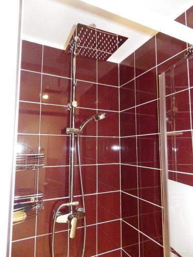 La salle de bains est pourvue d'une douche et de carrelage rouge. dans l'établissement la vague, à Les Sables-dʼOlonne
