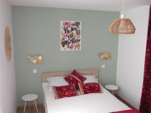 une chambre avec un lit avec des oreillers rouges dans l'établissement la vague, à Les Sables-dʼOlonne