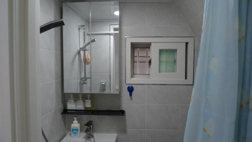 un baño con lavabo y espejo en Sinchon sweet house, en Seúl