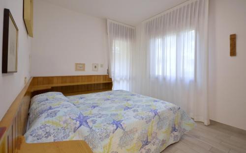 a bedroom with a bed with a blue comforter at Villa Negri in Lignano Sabbiadoro