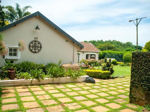 a white house with a garden in front of it at Hudson Haven Bed & Breakfast in Pietermaritzburg