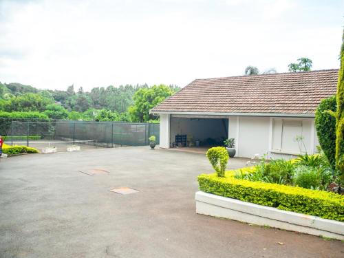 a building with a parking lot next to a fence at Hudson Haven Bed & Breakfast in Pietermaritzburg