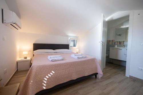 a bedroom with a large bed with two towels on it at Villa Giada in Campofelice di Roccella