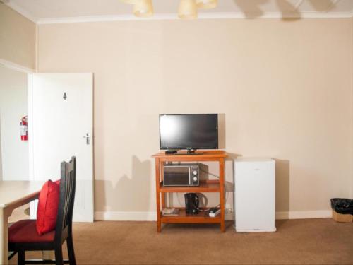a living room with a tv and a table with a microwave at Hudson Haven Bed & Breakfast in Pietermaritzburg