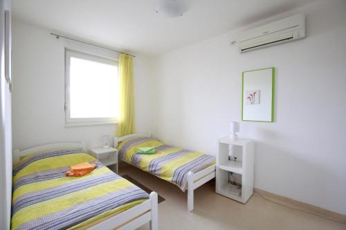 1 dormitorio con 2 camas y ventana en Apartment Hurcak, en Zagreb