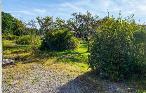 a yard with a bush and a house in the background at 2 Bedroom Cozy Home In Skruv in Skruv