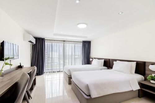 a hotel room with two beds and a television at SureStay By Best Western Iconic Suvarnabhumi in Samut Prakan