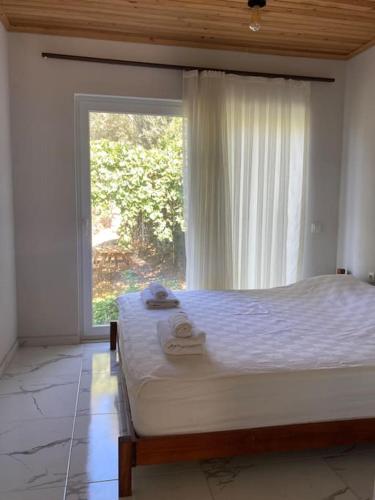 a bedroom with a bed and a large window at Magnificent sunset view in Fethiye