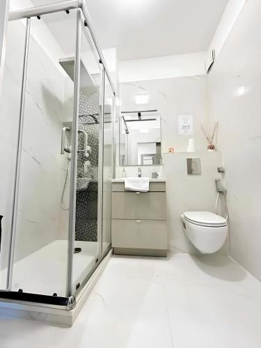 une salle de bain blanche avec douche et toilettes dans l'établissement Il Gioiello : Apt 2 pers, Clim, Piscine, Parking, à Antibes