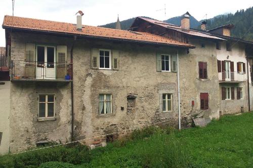 an old stone house on the side of a hill at La Casa dei Bottoni in Ossana