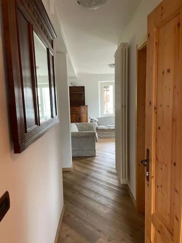 a room with a hallway with a window and a couch at La Casa dei Bottoni in Ossana