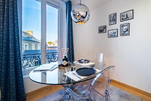 une table en verre dans une chambre avec fenêtre dans l'établissement Appart 2 personnes à 50m des commerces & mer, à Barneville-Carteret